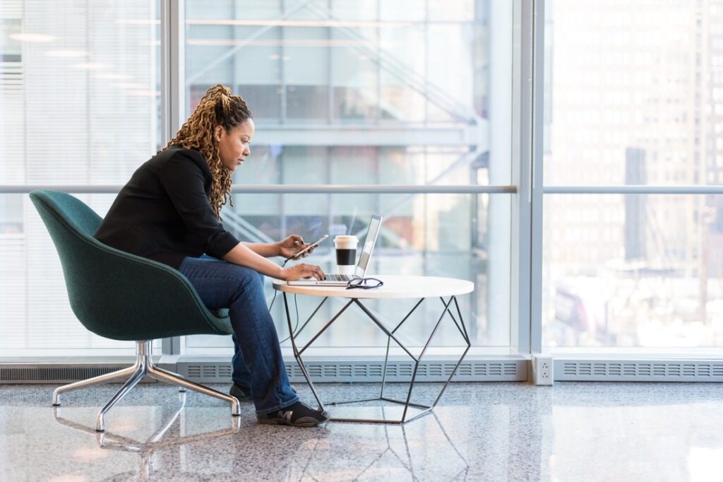 Woman working with poor posture at a laptop, a common cause of upper back and neck pain
