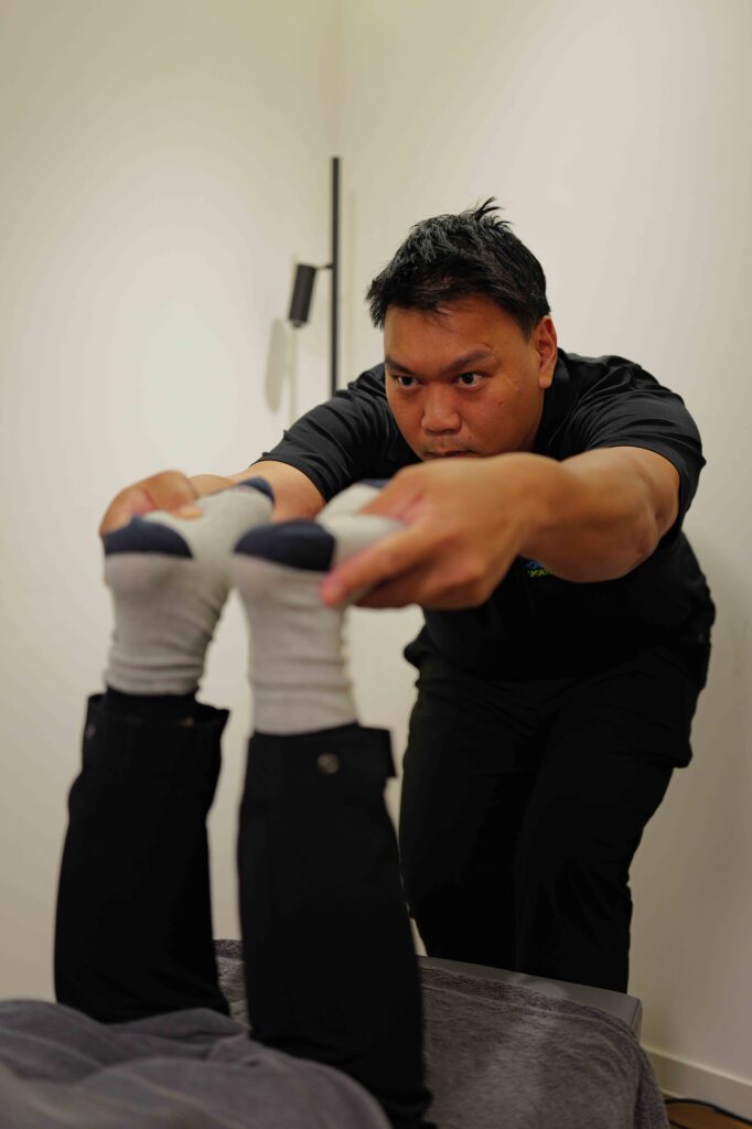Chiropractor at Total Health Hong Kong assessing a patient during a sports injury treatment session