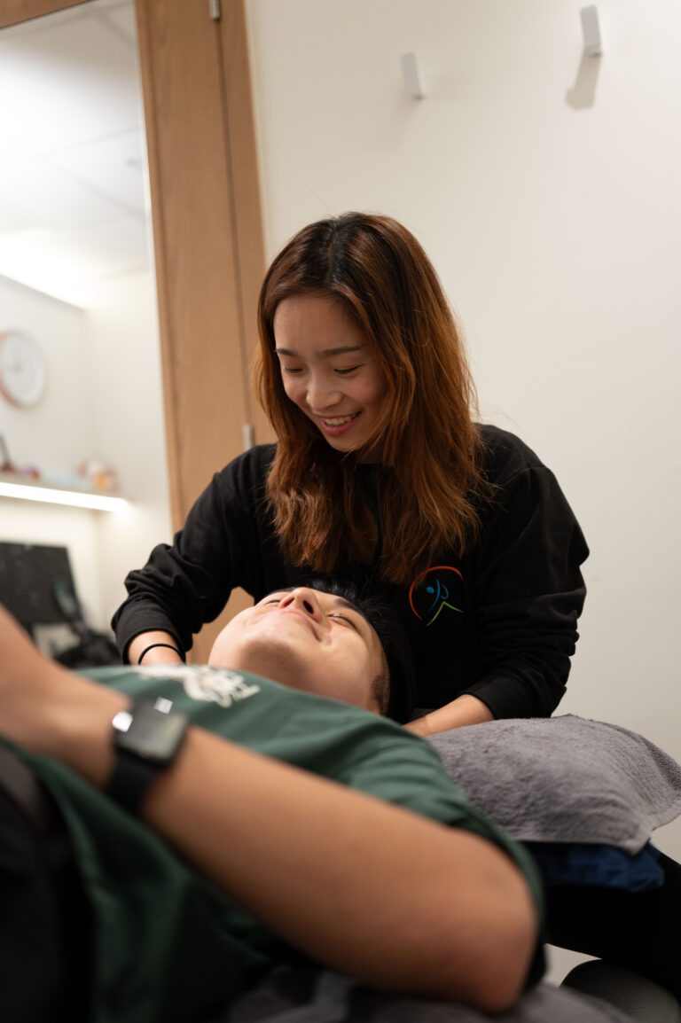 Therapist treating a patient's head and neck in the clinic