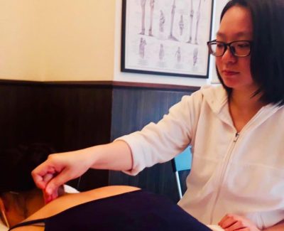 A female getting traditional Chinese medicine therapy done by Grace Yu.